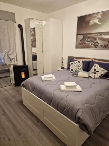 um quarto com uma cama grande e toalhas em APPARTAMENTO STELLA MARE em Lignano Sabbiadoro