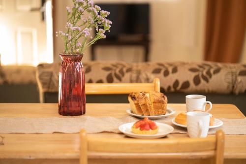 una mesa con dos platos de comida y un jarrón con flores en Cozy Renting Casa, en Santa Rosa de Copán