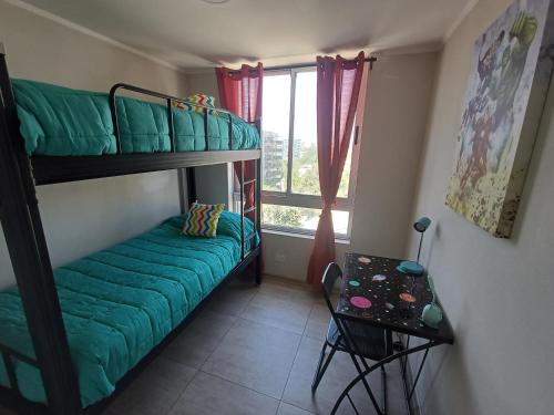 um pequeno quarto com um beliche e uma mesa em Departamento Ines de Suarez, La Florida em Santiago