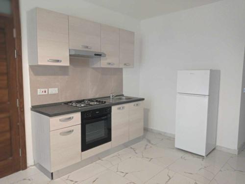 a kitchen with a stove and a refrigerator at Poppy Court in Marsaskala