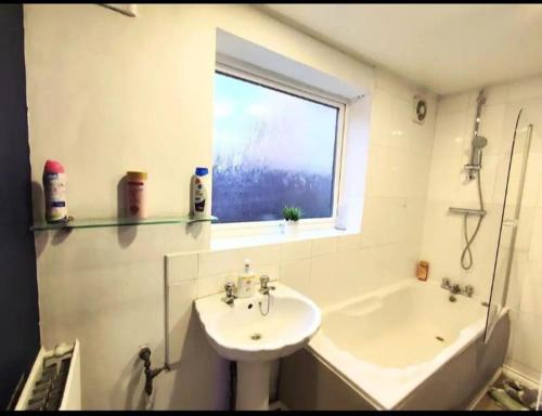 a bathroom with a sink and a toilet and a window at Cozy Room Near The City Center in Old Walker