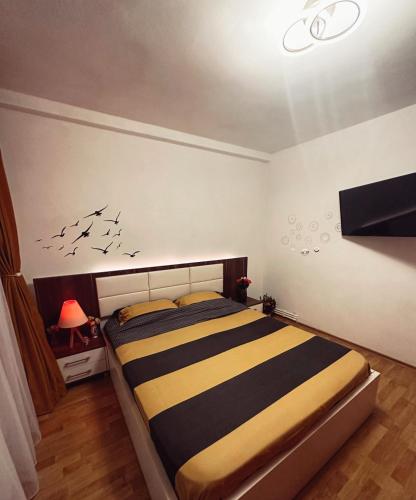- une chambre avec un lit et une télévision murale dans l'établissement Vintage Apartament, à Constanţa