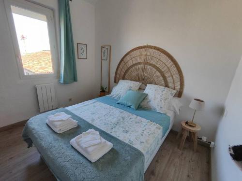 ein Schlafzimmer mit einem Bett mit zwei Handtüchern darauf in der Unterkunft Appartement de Charme L'Isle-sur-la-Sorgue sur la Sorgues in LʼIsle-sur-la-Sorgue