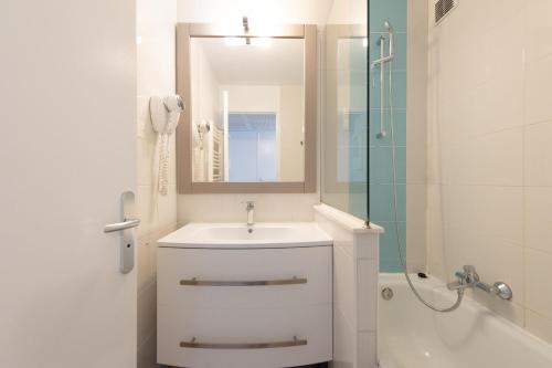 une salle de bain blanche avec un lavabo et une douche dans l'établissement Stylish 2 rooms in the heart of Cannes, à Cannes