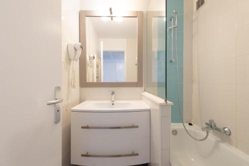 a white bathroom with a sink and a shower at Stylish 2 rooms in the heart of Cannes in Cannes
