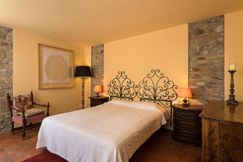 a bedroom with a white bed and a chair at B&B Mulino Marsa in CastellʼArquato