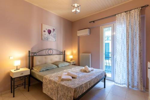 a bedroom with a bed and a large window at Fivos apartment in Zakynthos Town