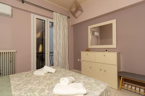 una camera con letto, cassettiera e specchio di Fivos apartment a Città di Zante