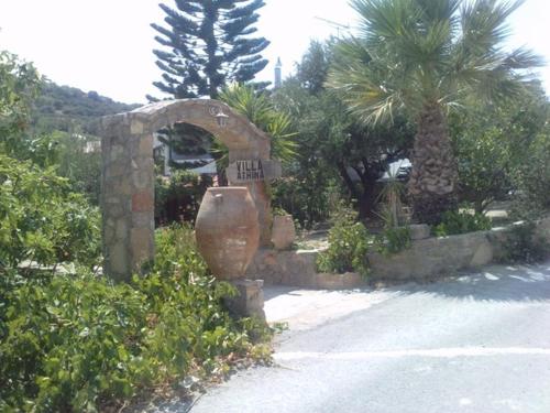 a stone arch with a large vase in a garden at Athina Villas in Istro