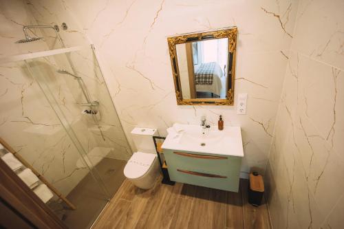 ein Badezimmer mit einem Waschbecken, einem WC und einem Spiegel in der Unterkunft Albergue Turístico LAbellaVILLA in Rincón de Soto