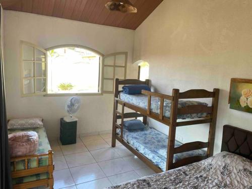 a bedroom with two bunk beds and a window at Rancho Saramago in Jundiaí