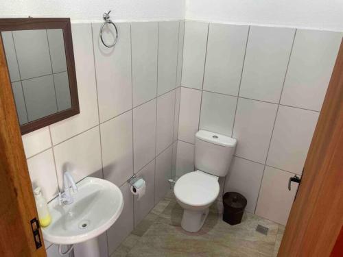 uma casa de banho com um WC branco e um lavatório. em Rancho Saramago em Jundiaí