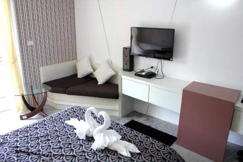 Pokój z dwoma białymi łabędzie siedzącymi na łóżku w obiekcie Replay Condo Studio Room w mieście Bangrak Beach