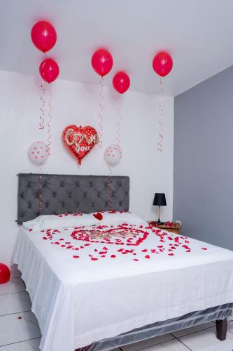 Posada La Rosa في Santa Ana: غرفة نوم مع سرير بقلوب حمراء على الحائط