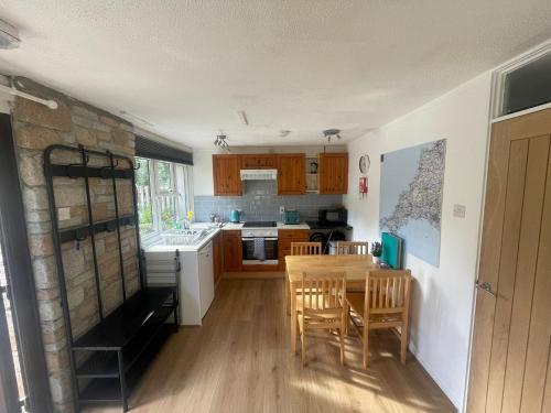 a kitchen with a table and chairs and a sink at Woodland bungalow, fantastic location in Uny Lelant