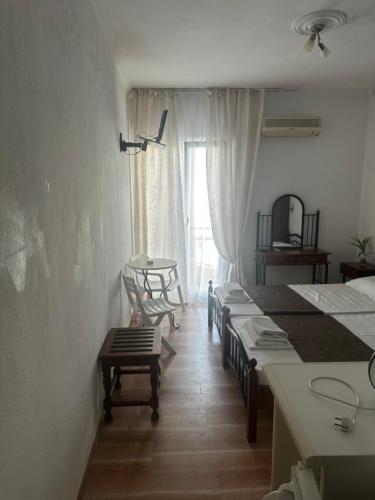 a group of beds in a room with a window at Pansion Angela in Skiathos Town