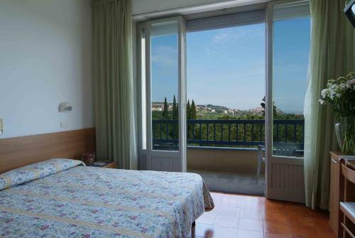 a hotel room with a bed and a large window at Albergo Le Sorgenti in Chianciano Terme