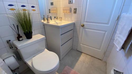 a white bathroom with a toilet and a sink at Terraza propia y baño privado in Santiago