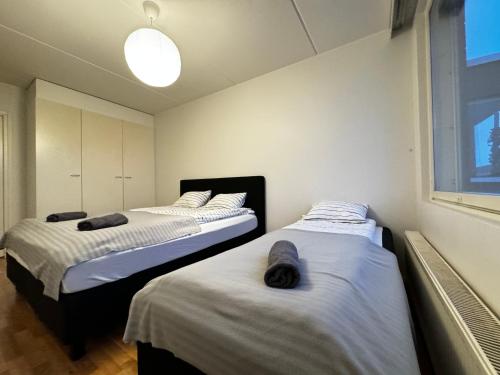two twin beds in a room with a window at DownTown Rooms And Sauna in Helsinki