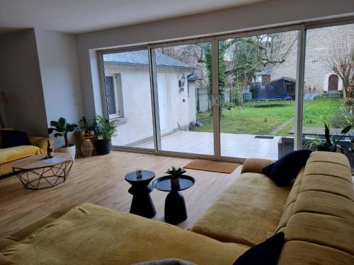 - un salon avec un canapé et une grande fenêtre dans l'établissement Maison de charme - accès autonome, à Orléans