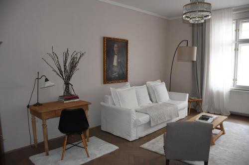 een woonkamer met een witte bank en een tafel bij Center Marvel in Ljubljana