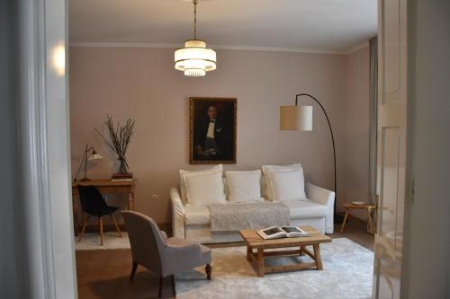 een woonkamer met een witte bank en een tafel bij Center Marvel in Ljubljana