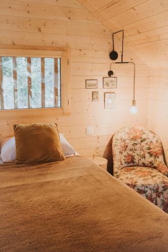 une chambre avec un lit et une chaise dans l'établissement Cabane de la Saône by Lyon Country House, à Caluire-et-Cuire