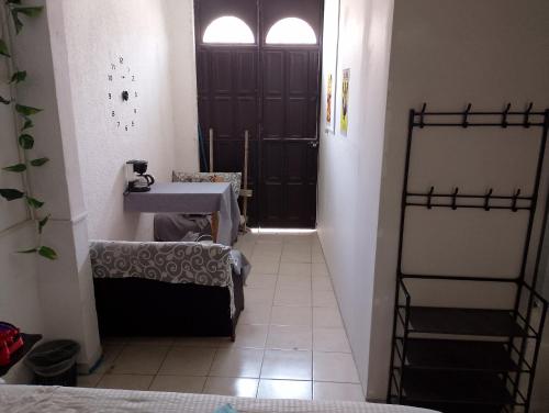 een badkamer met een wastafel, een spiegel en een deur bij Hab privada entrada independiente in Tuxtla Gutiérrez