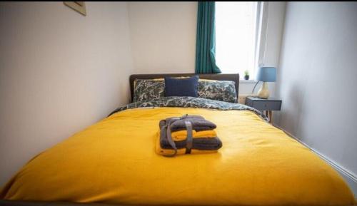 a yellow bed with a backpack on top of it at Northumberland Cozy Palace B in Old Walker