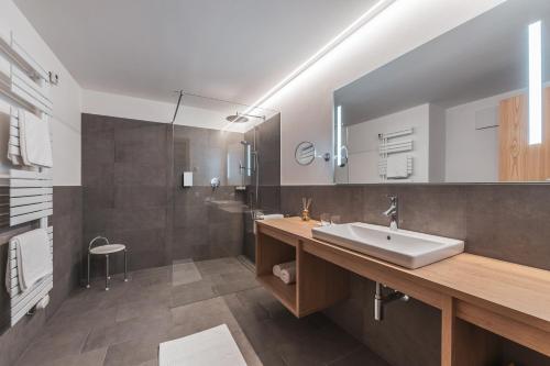 a bathroom with a sink and a large mirror at Charming Suite by Dornsberg Panoramic Apartments in Schenna