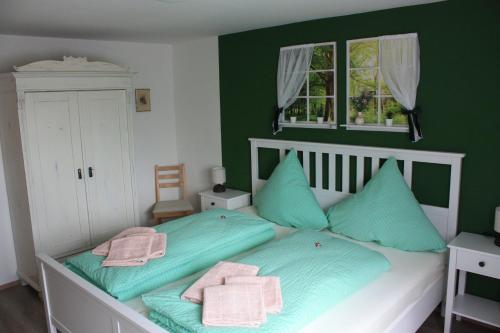 um quarto com paredes verdes e uma cama com almofadas azuis em Fewo Am Geyersberg em Oberschöna