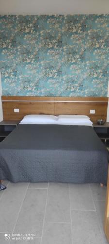 una camera con un letto con una parete floreale di Corte Bottura agriturismo a Castelnuovo del Garda