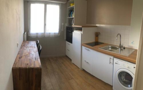 uma cozinha com um lavatório e uma máquina de lavar roupa em Appartement Saint-Malo Centre - Arrivée autonome em Saint Malo