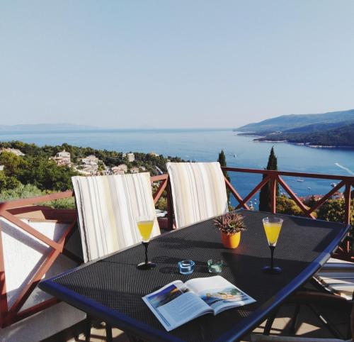 een zwarte tafel met twee glazen wijn op een balkon bij Sea View K Loft in Rabac