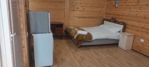 a bedroom with a bed and a refrigerator in it at NAREK B&B in Goris