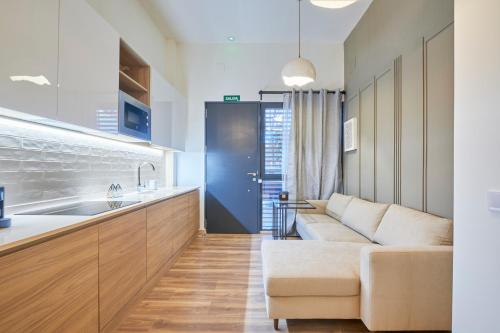 een woonkamer met een bank en een keuken bij Madrid Urban Comfort in Madrid