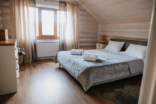 ein Schlafzimmer mit einem Bett mit zwei Handtüchern darauf in der Unterkunft Vila Mila in Mykulytschyn