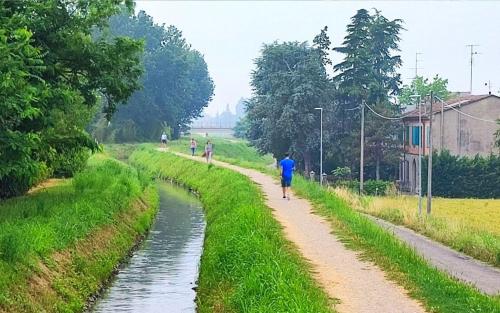 a man walking down a dirt road next to a river at B&B La Dolce Riva in Lugo
