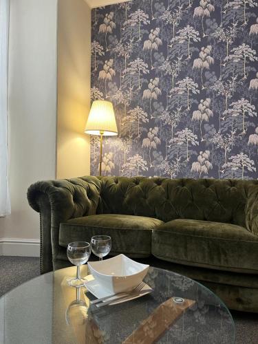a living room with a couch and a glass table at Beautifully presented Victorian Apartment within walking distance to Llandudno beach in Llandudno