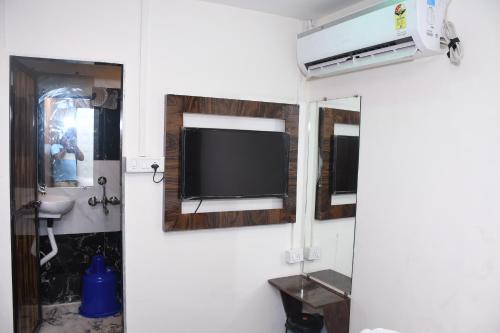 ムンバイにあるAirport Cabin Stay Mumbai Near T2の壁にテレビが付いた部屋