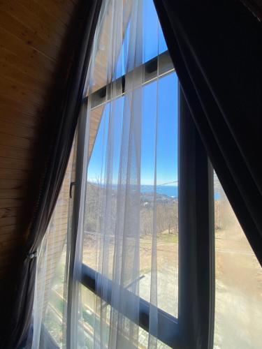 a window with a view of the ocean from a house at Cottage "Sunset" in Batumi