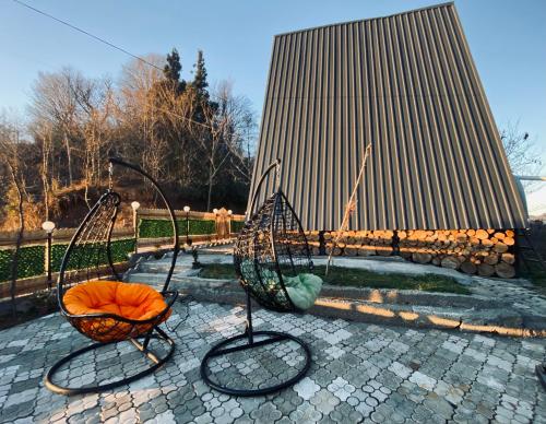 a couple of swings in front of a building at Cottage "Sunset" in Batumi