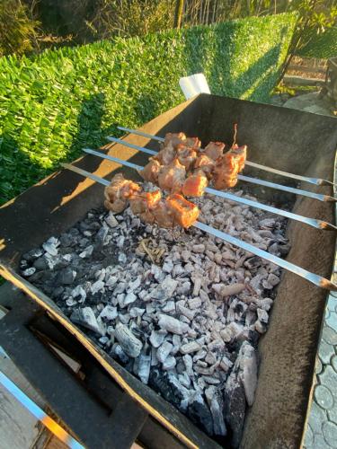 a grill with meat and other food on it at Cottage "Sunset" in Batumi