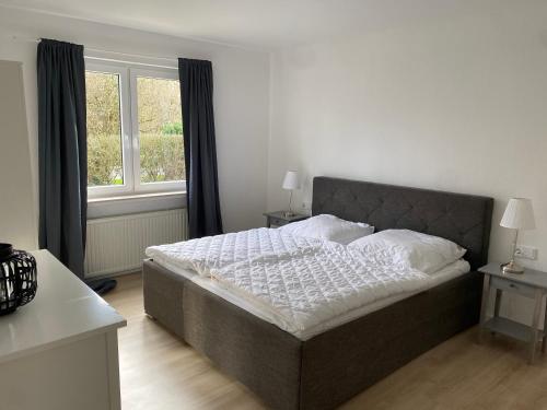 1 cama en un dormitorio con ventana grande en Gemütliches Ferienhaus in Küstennähe, en Wilhelmshaven