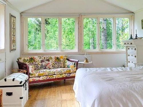 um quarto com uma cama, um sofá e janelas em Holiday home SÖDERALA em Söderala