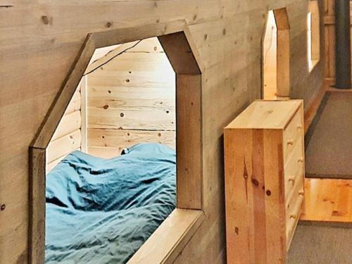 a bed in a wooden room with a mirror at Holiday home Bureå in Bureå