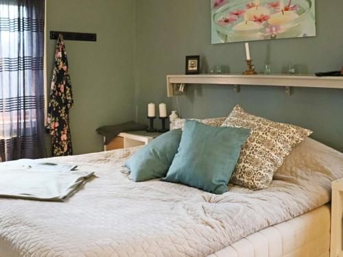 Un dormitorio con una cama con almohadas. en Holiday home LAHOLM X en Laholm