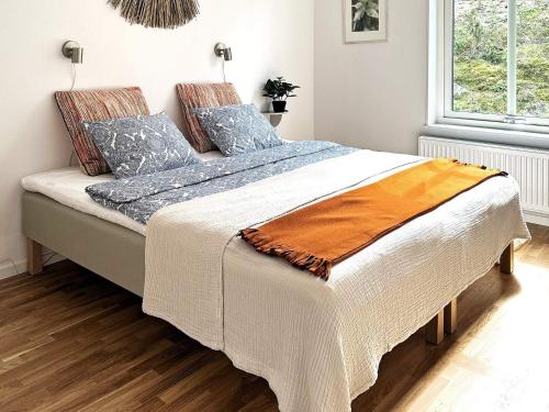 ein Schlafzimmer mit einem großen Bett mit blauen Kissen in der Unterkunft Holiday home VIKBOLANDET II in Arkösund