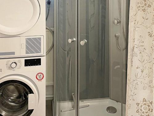 a glass shower door next to a washing machine at Holiday home SÖLVESBORG X in Sölvesborg