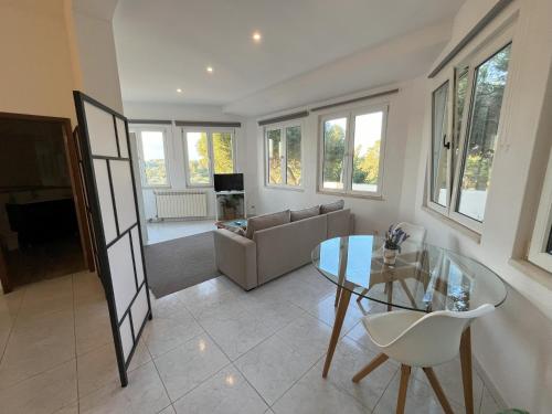 a living room with a glass table and a couch at Quinta Nova Relax & Spa - Vale del Rey in Carvoeiro